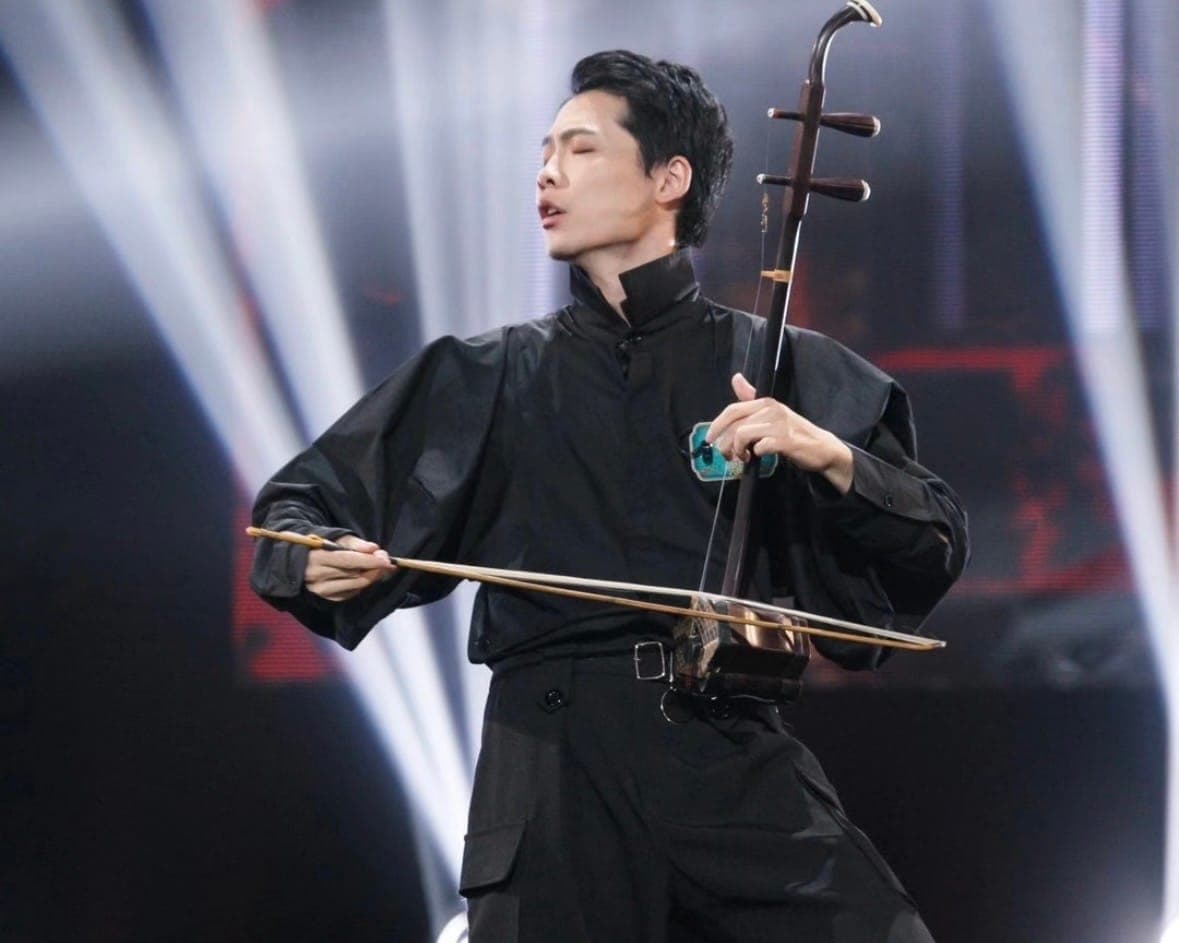 Male Erhu artist performing on stage in stand position